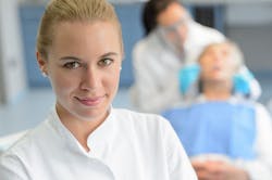 Dental Assistant With Dentist In Background Dental Assistant With Dentist In Background