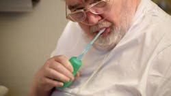 A patient uses the GripEazy Expand to brush his teeth.