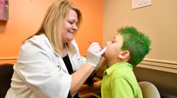 Dawn Brewer, APRN, applies fluoride varnish at a wellness check.