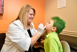 Dawn Brewer, APRN, applies fluoride varnish at a wellness check. Dawn Brewer, APRN, applies fluoride varnish at a wellness check.
