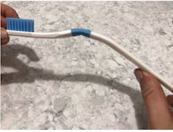 Figure 3: When greater than 150 g of pressure is applied to the ZentFlex toothbrush, it bends and emits a 'clicking' sound at the blue junction of the neck and handle of the toothbrush. Figure 3: When greater than 150 g of pressure is applied to the ZentFlex toothbrush, it bends and emits a 'clicking' sound at the blue junction of the neck and handle of the toothbrush.
