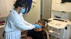 Radwan Almomani, DMD, administers a COVID-19 test to a patient at Refresh Dental in New Castle, Pennsylvania.