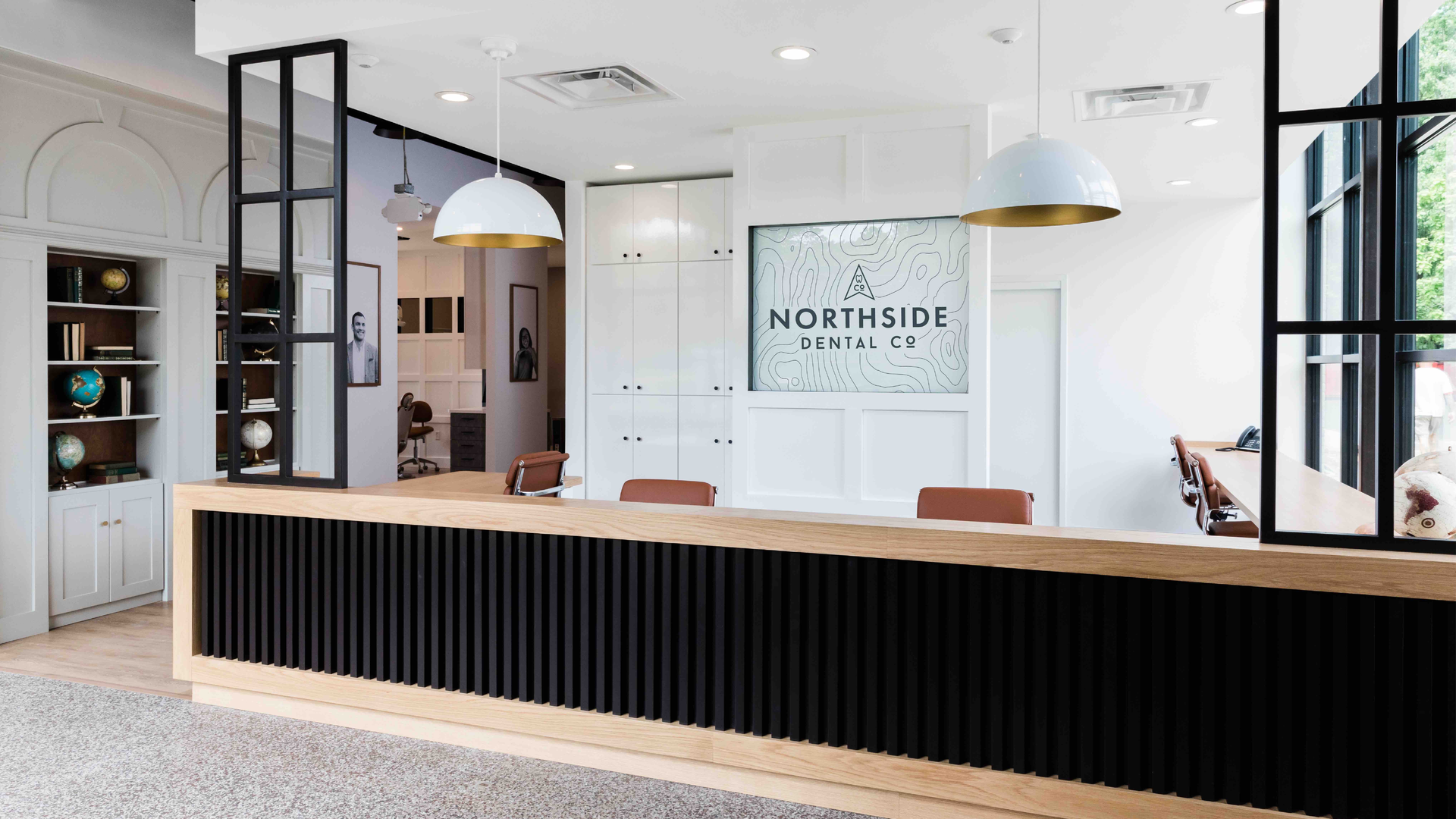 The digital signage behind the administrative desk changes depending on which practice is working that day.