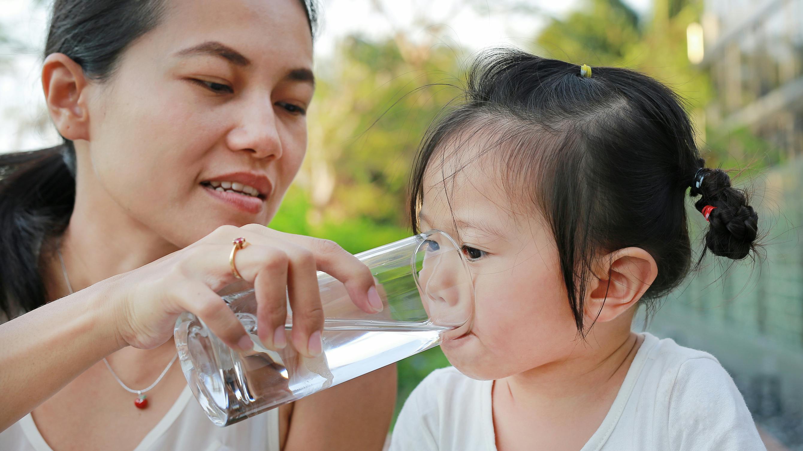 Mother giving child water