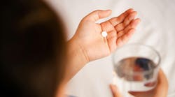 Person holding a pill Person holding a pill