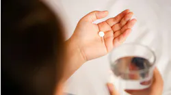 Person holding a pill Person holding a pill