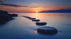 steppingstones going out over water into the sunset steppingstones going out over water into the sunset