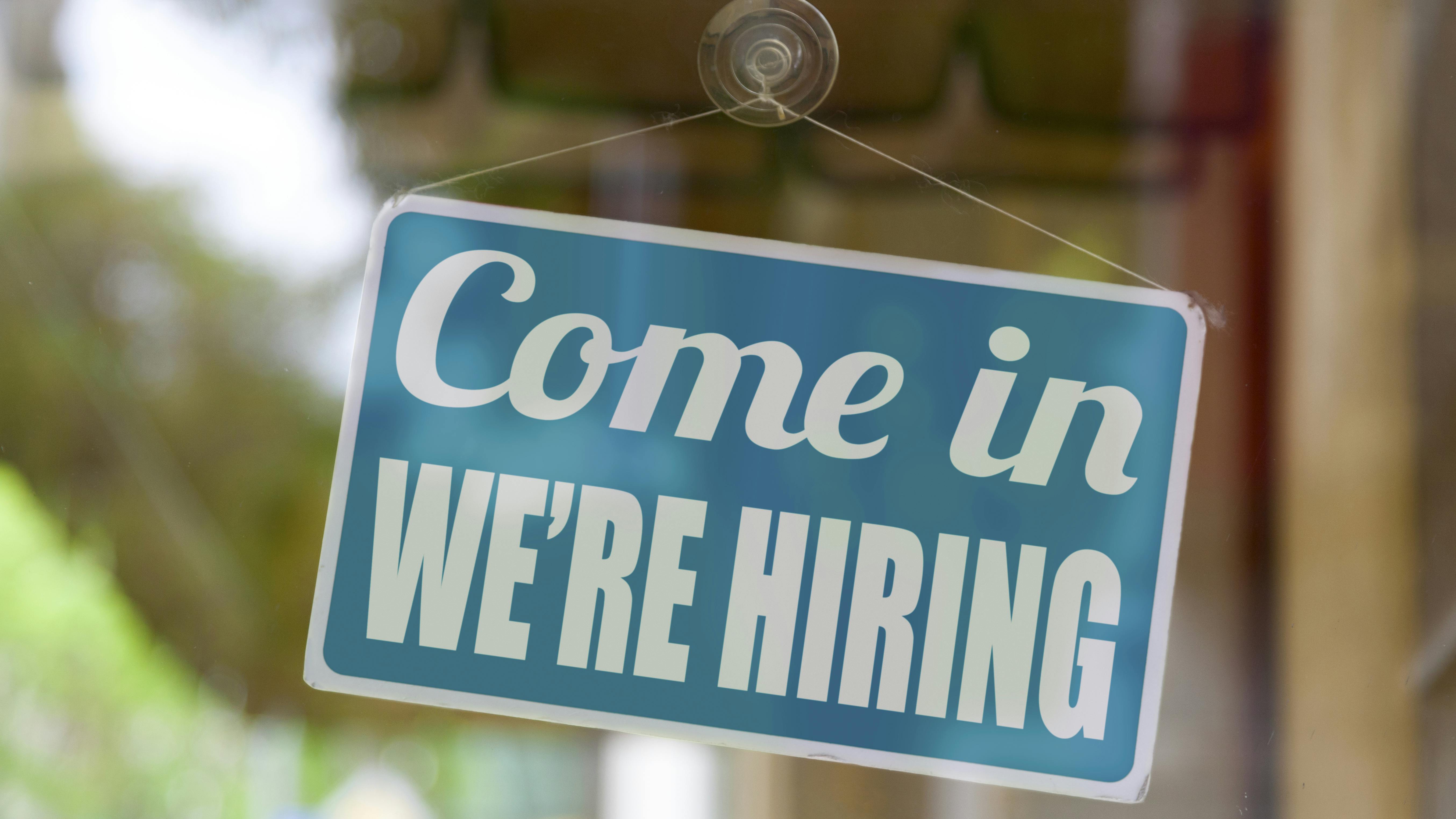'Come in we're hiring' sign in window