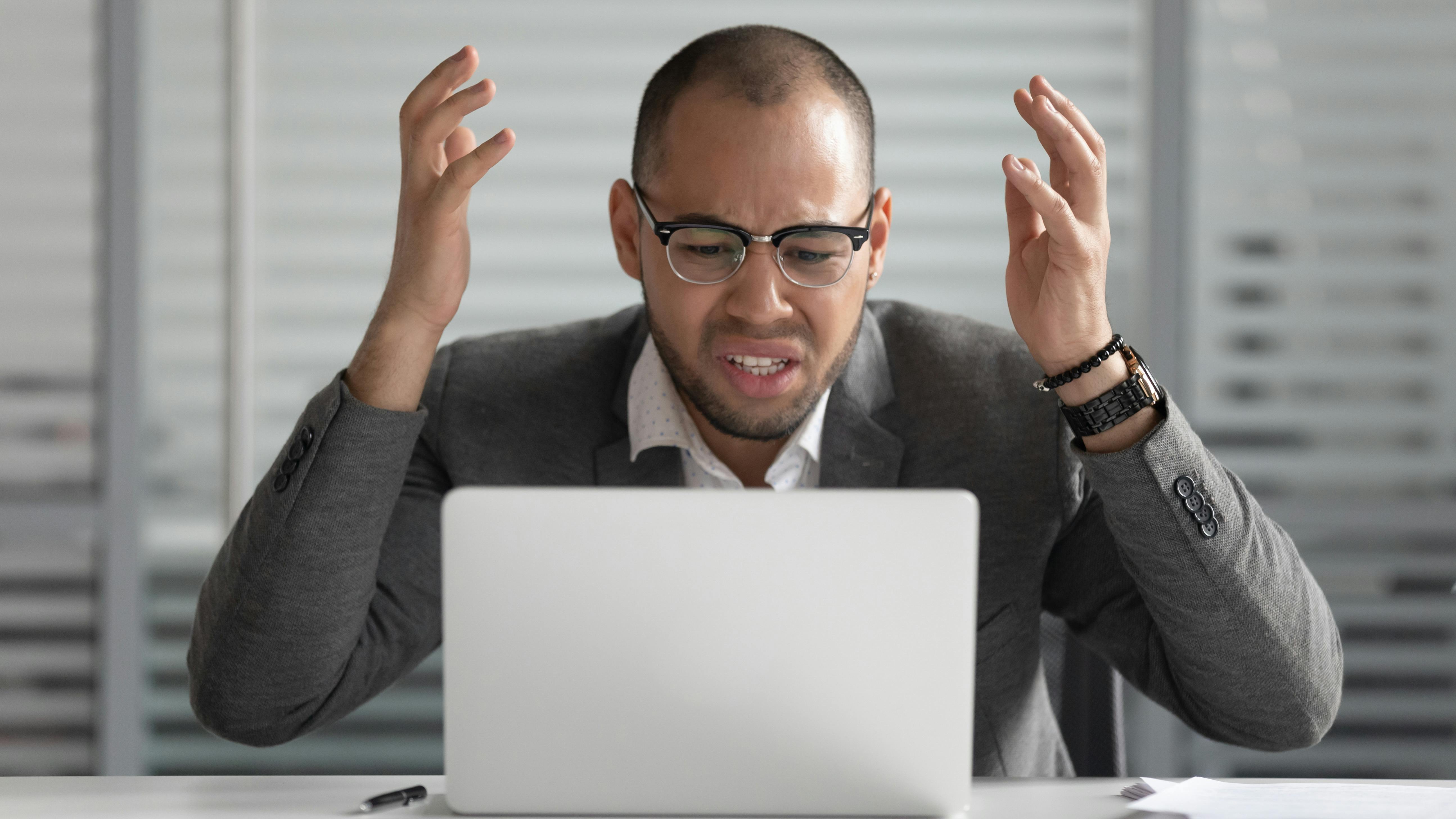 Frustrated man sitting at laptop