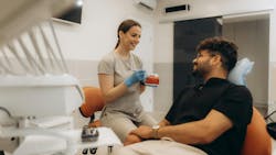 dental professional talking to a patient in the dental chair dental professional talking to a patient in the dental chair
