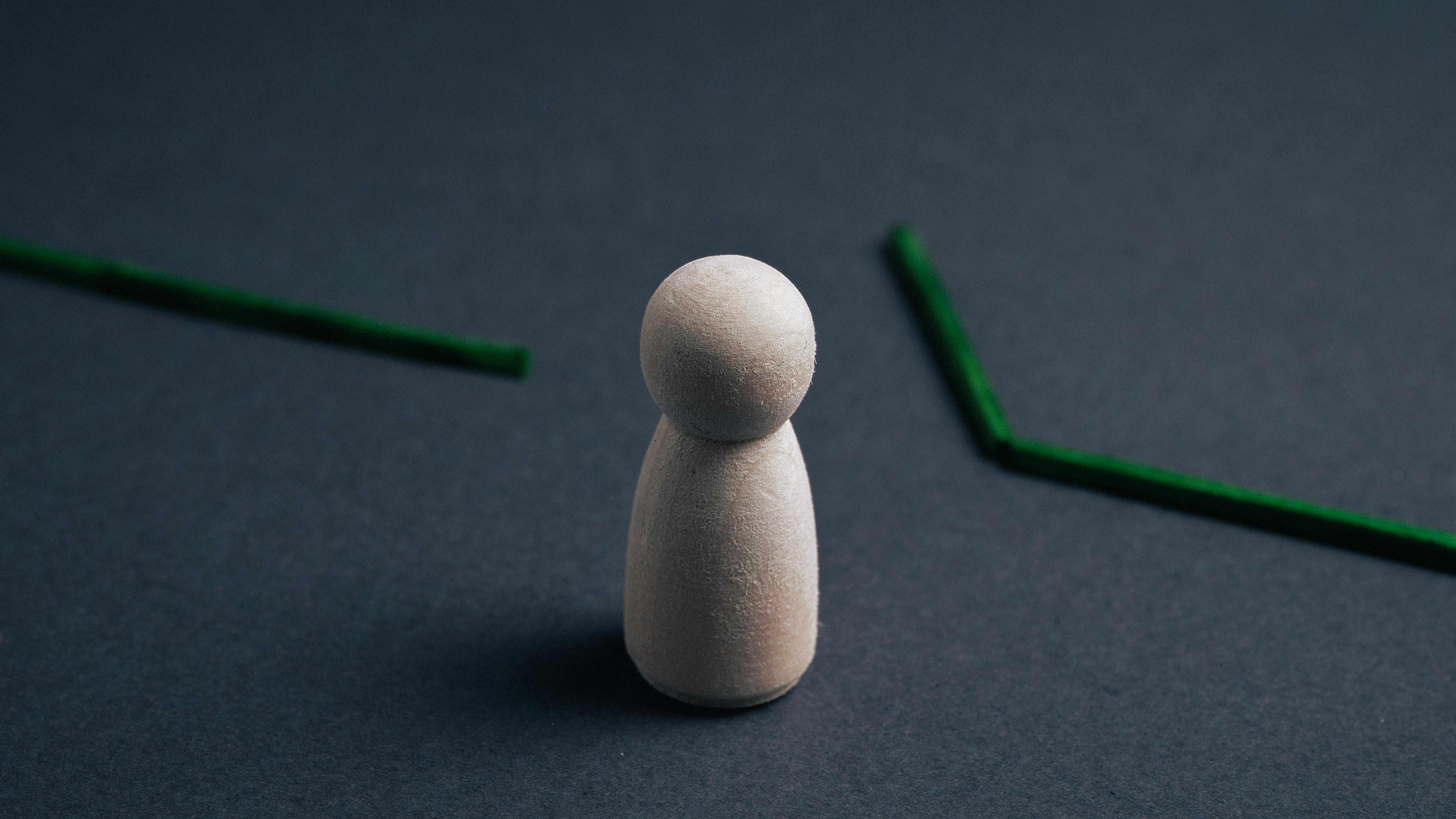 Wooden figure in front of a broken line, symbolizing bottleneck in the process
