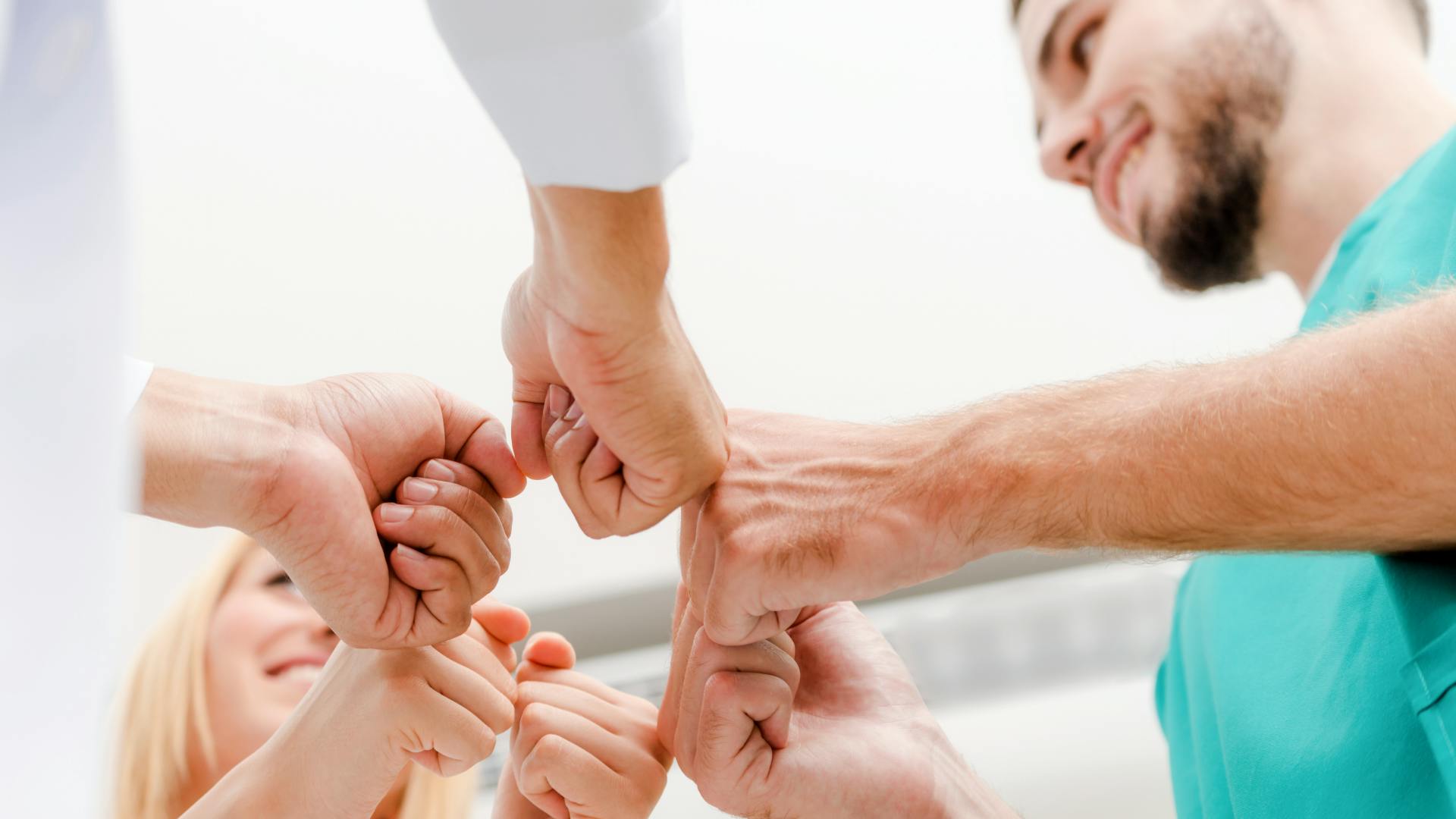 Dental staff putting their hands in a circle