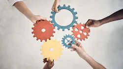 arms of people with different races holding gears together in a symbol of collaboration arms of people with different races holding gears together in a symbol of collaboration