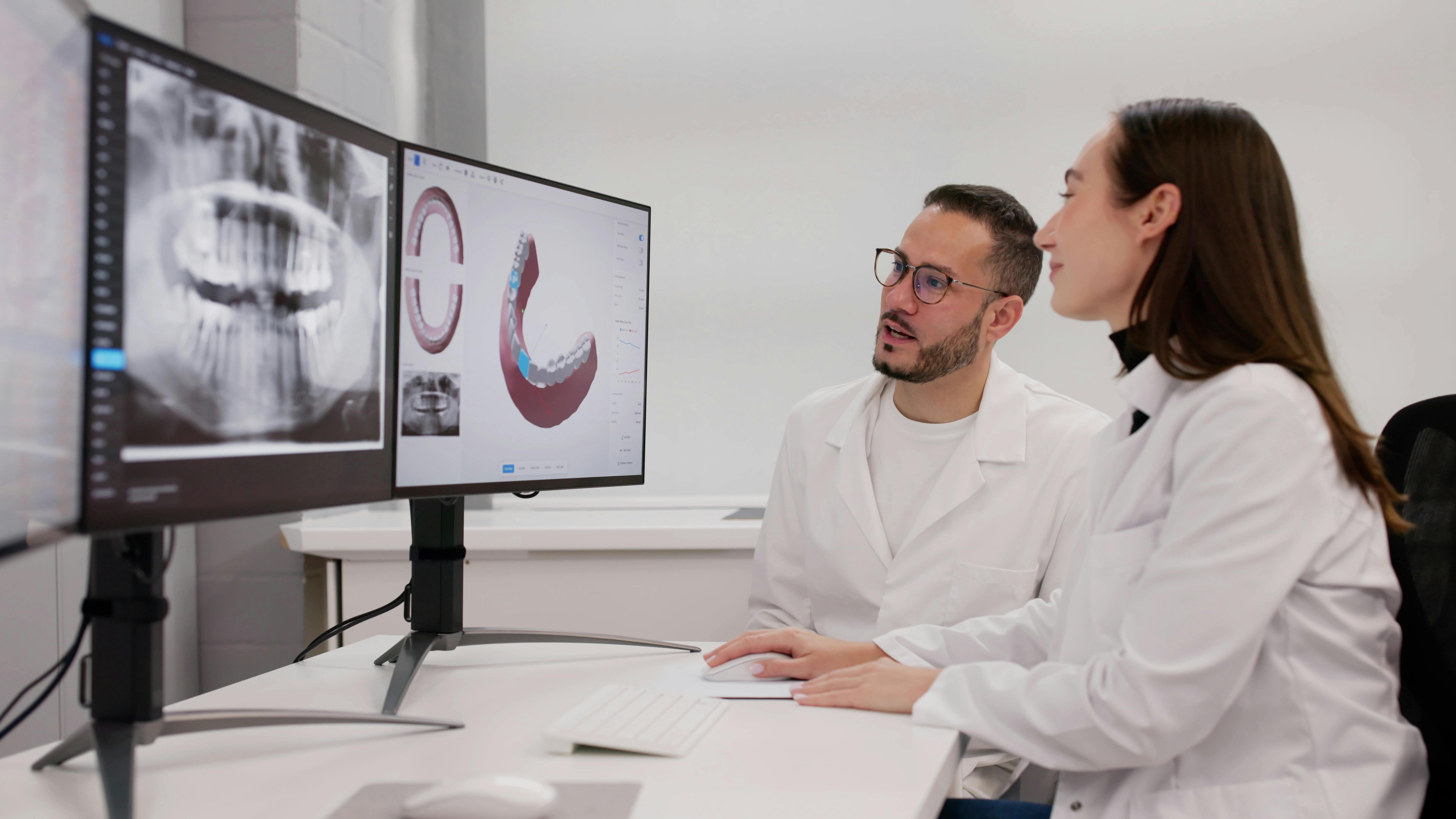 two dentists looking at 3D scans on screens