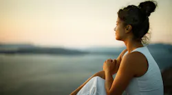 woman in a reflective mood sitting outside gazing into the distance
