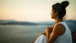 woman in a reflective mood sitting outside gazing into the distance