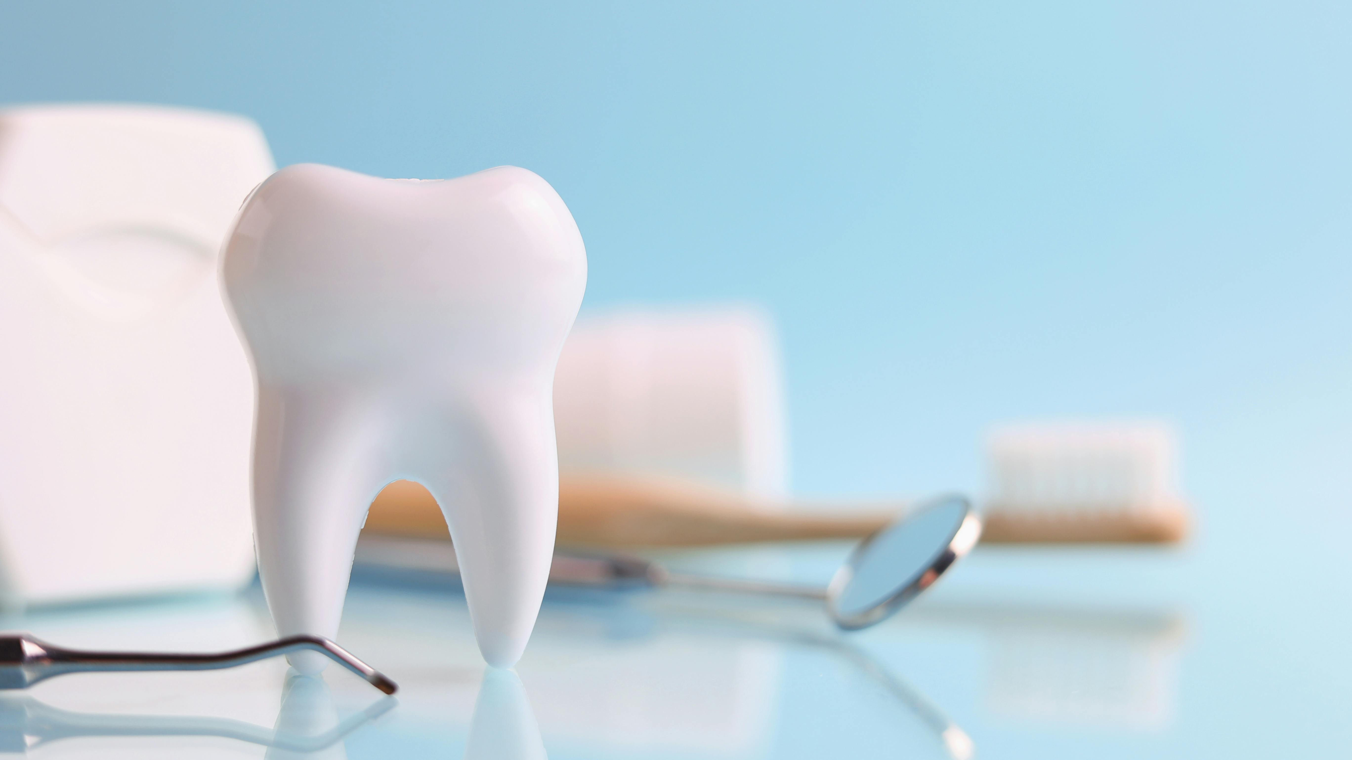 a tooth, dental floss, toothbrush, mirror, and a dental instrument