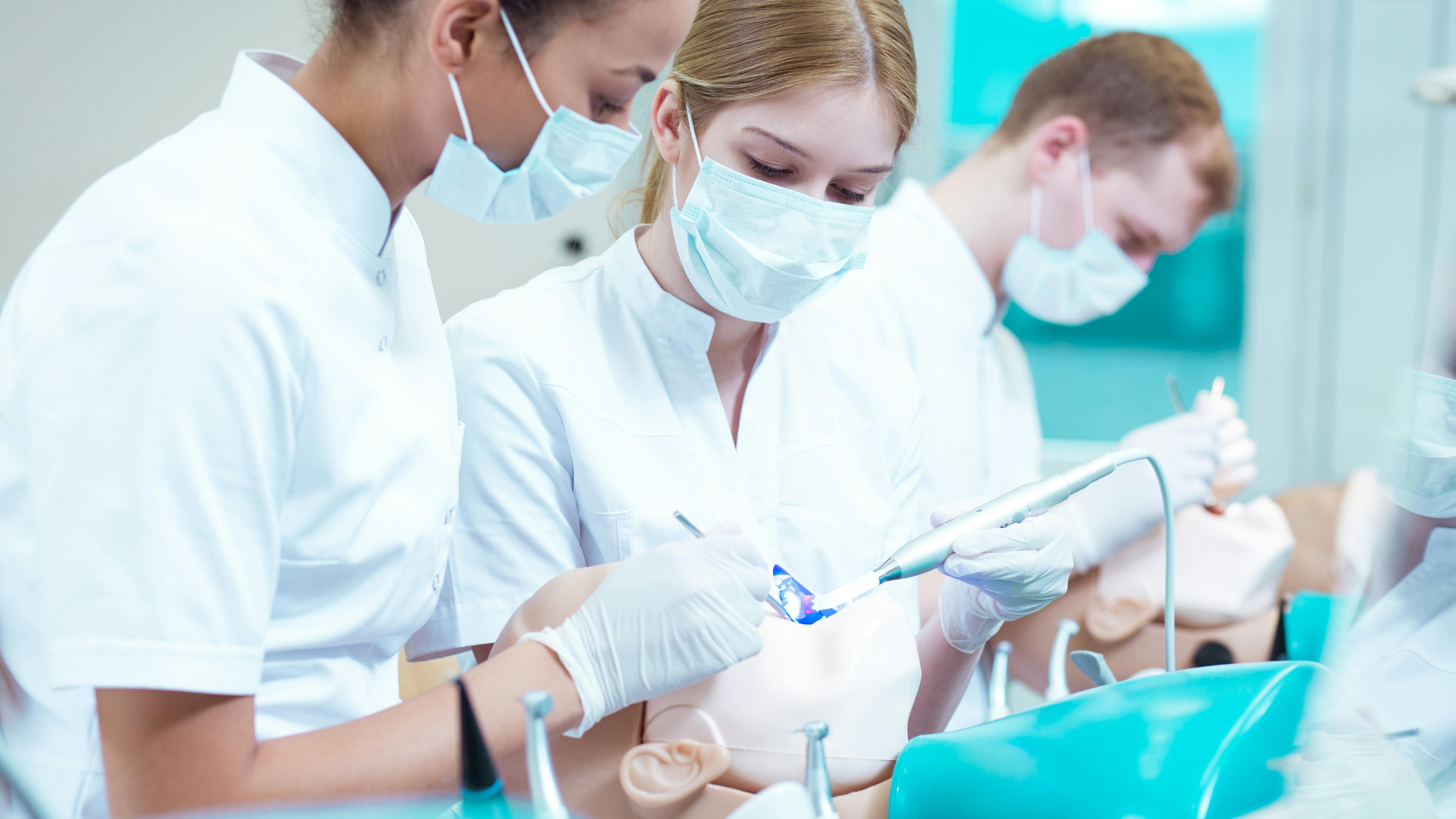 dental hygiene students working on a manikin